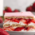 strawberry eclair cake on white table with pudding and fresh strawberries
